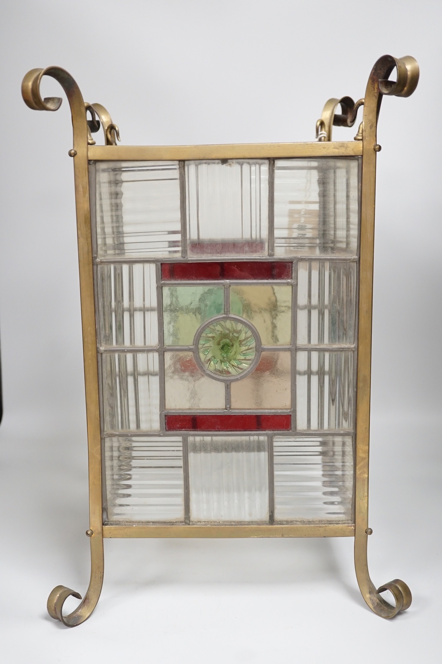 An Arts and Crafts brass and stained glass porch lantern. 46cm tall